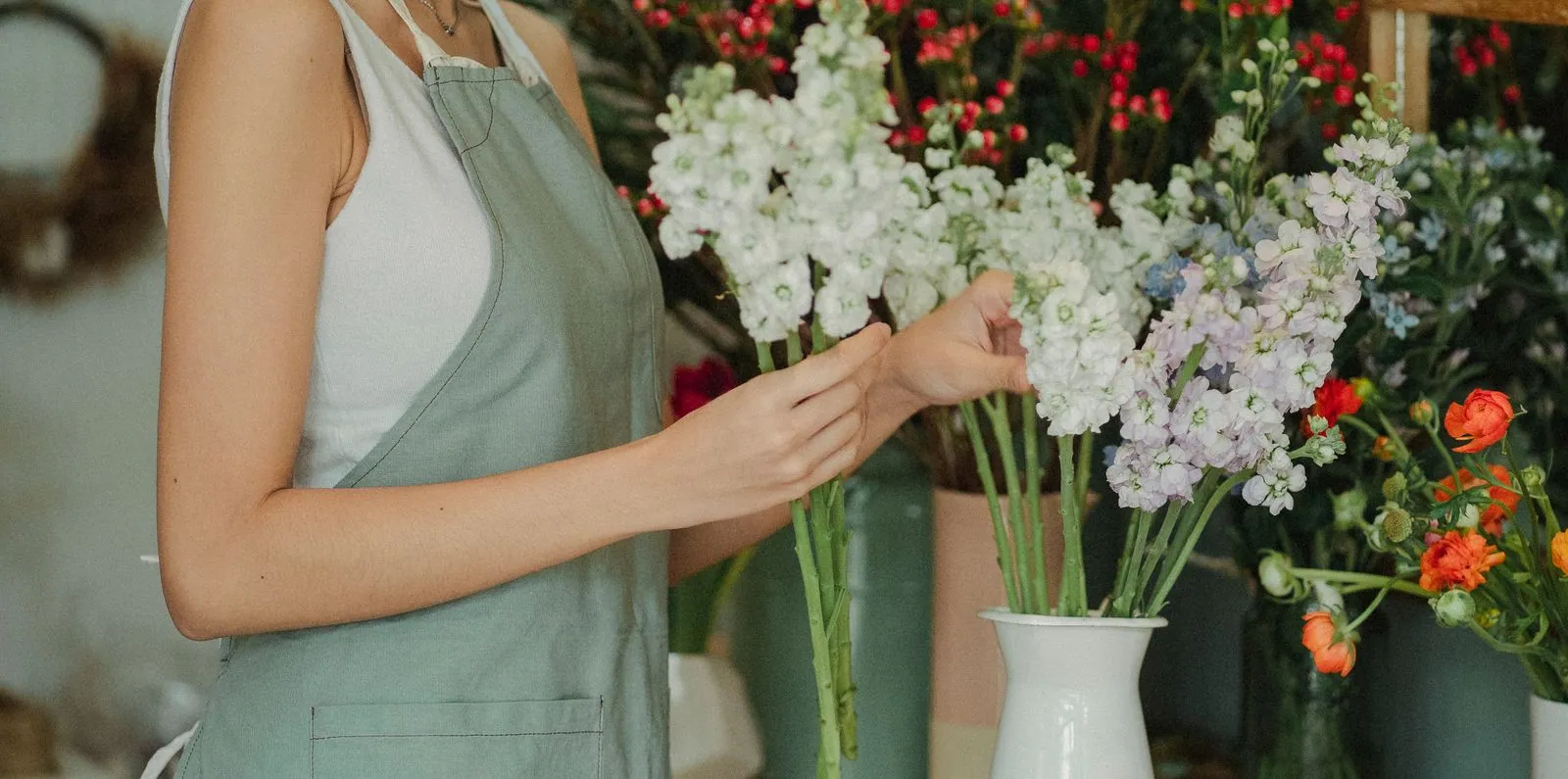 Florist selecting white flowers at a workshop table